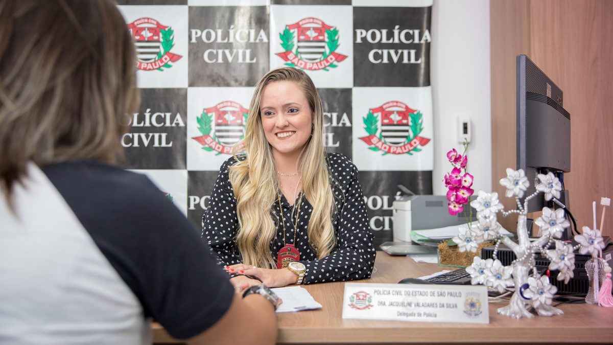 Delegada atende uma mulher em delegacia da Polícia Civil de São Paulo