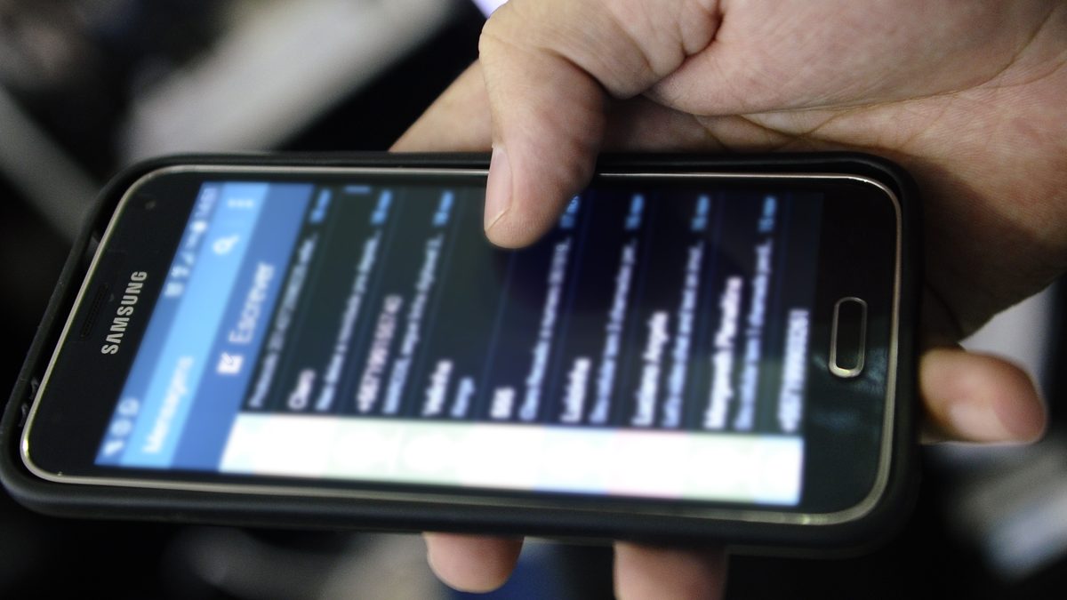 Mão segura um celular Android em close