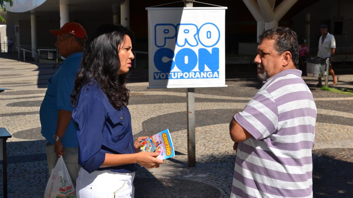Atendente do Procon de Votuporanga (SP) orienta um consumidor na rua, no Dia do Consumidor