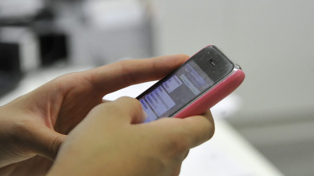 Mãos seguram um celular e digitam uma mensagem